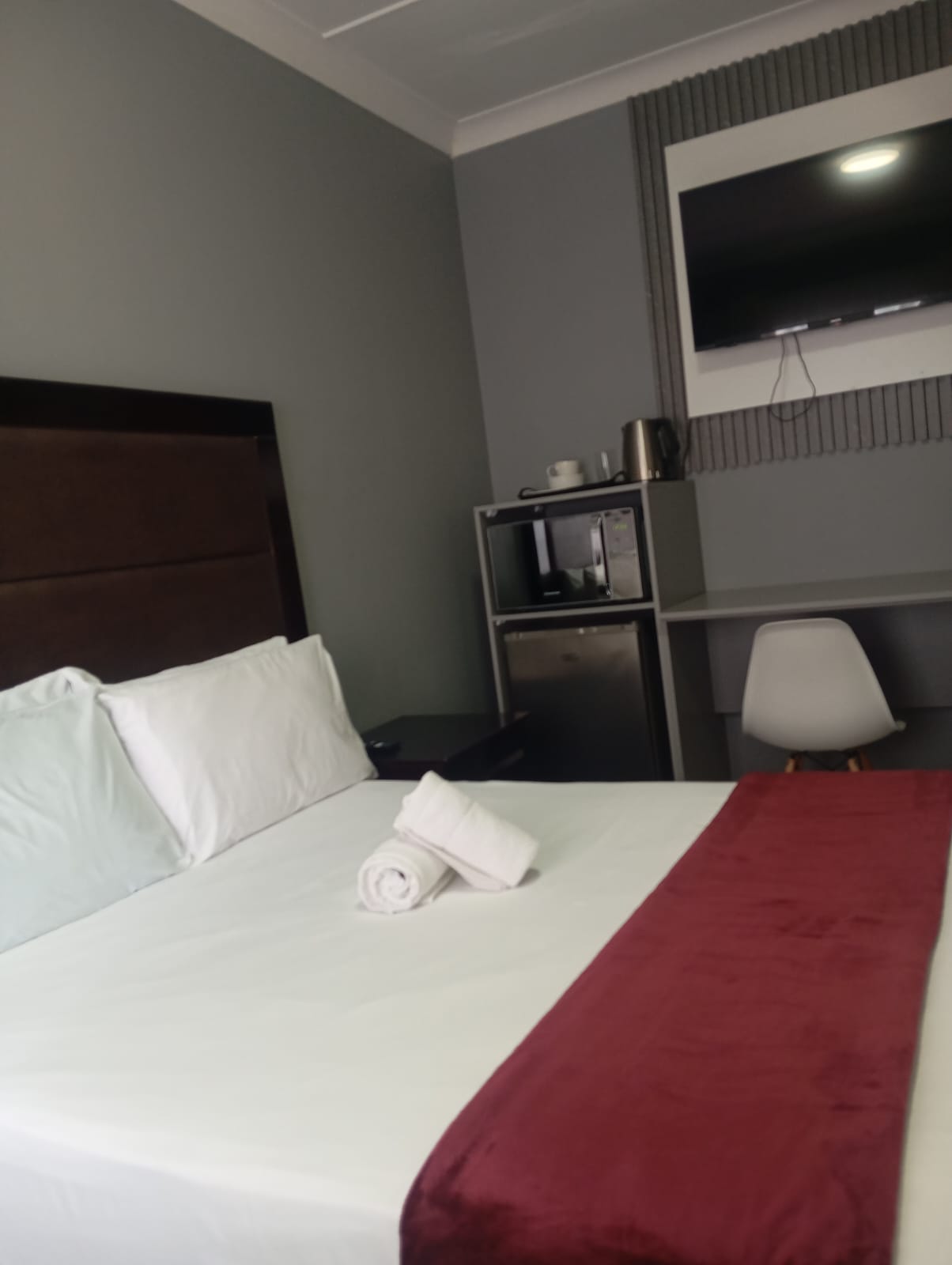 Lodge@36 room with flat-screen TV, bar fridge, kettle and work desk