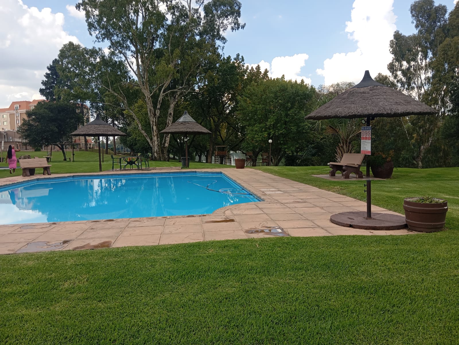 Villa swimming pool with lawn and shaded seating
