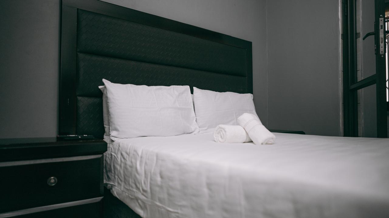 Lodge@36 bedroom with fresh linen and rolled towels